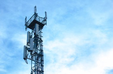 Metal kule telefon ve iletişim. Karşı gökyüzü bulutlu.