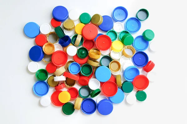 Plastic bottle caps on a white background. View from above.