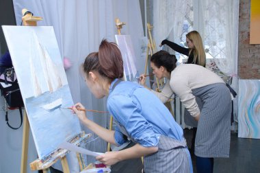 Novosibirsk 02-24-2018. Bir sanat atölyesi meslekte. Kızlar resimler tuval üzerine akrilik boya ile boyayın.