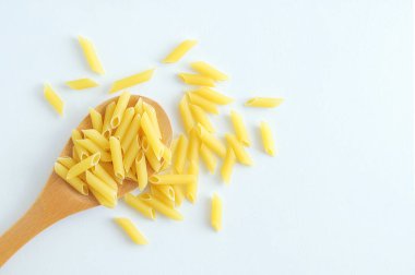 Tahta kaşık ve saçılma makarna erişte. Beyaz arka plan.