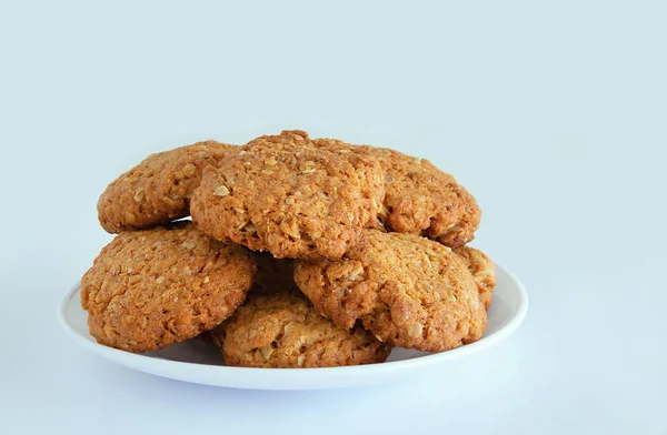 Yulaf ezmeli kurabiye ile tahıl ve tohum beyaz tabakta. Beyaz arka plan. Yakın çekim.