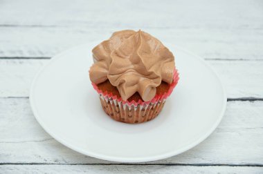 Beyaz ahşap zemin üzerinde beyaz bir plaka üzerinde Çikolata kremalı bisküvi kek.