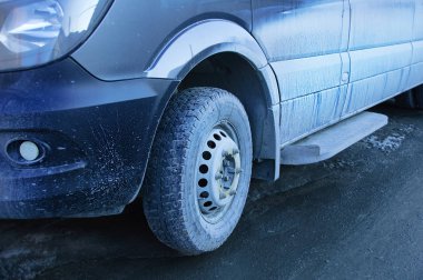 Yolda kirli mavi araba. Kuru toprak yakın çekim.