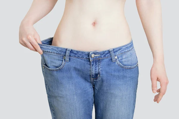 Concepto Dieta Pérdida Peso Mujer Jeans Grandes Sobre Fondo Gris —  Fotos de Stock