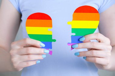 Beyaz bir kızın elinde Lgtb sembolleri olan bir kalbin yarısı.