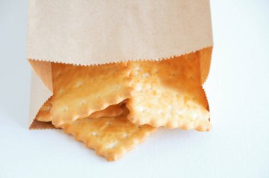 Beyaz arka plan üzerinde bir zanaat paketi yakın çekim kraker çerezleri.