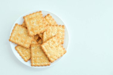 Beyaz bir tabakta krakerli kurabiye. Beyaz arka plan. Yukarıdan görüntüle.