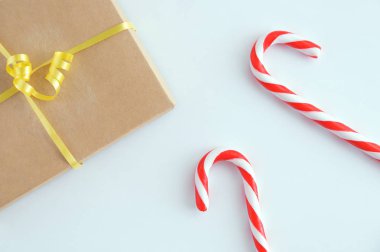 İki Noel şekeri, karamel ve beyaz arka planda bir el işi kutusunda hediye..