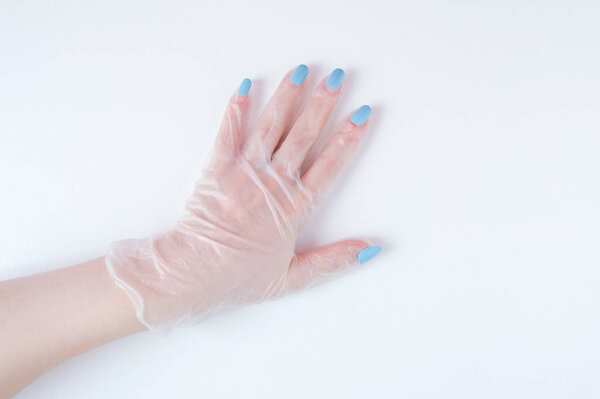 Manicure on a woman hand on top of a protective glove on a white background.