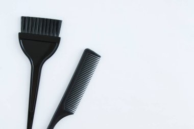 Kuaför aletleri. Plastik siyah tarak ve fırça beyaz arkaplandaki renk saçı için.