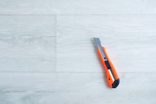 Bauschreibwaren Orangefarbenes Messer Auf Weißem Holzboden — Stockfoto