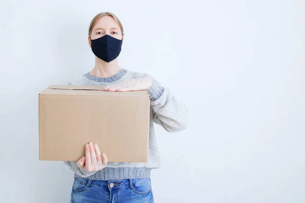 Caucasian Woman Cardboard Box Her Hands Black Protective Mask Her — Stock Photo, Image