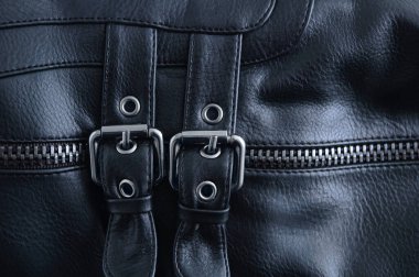 Siyah deri bir ayakkabının üzerinde iki metal toka..