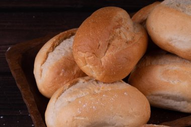 Ahşap bir arka plan üzerinde ekmek sepeti çörekler, düşük anahtar