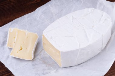 Ahşap rustik bir masada dilimlenmiş kokulu camembert peyniri