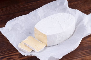 Ahşap rustik bir masada dilimlenmiş kokulu camembert peyniri