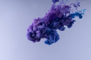 Renkli Mürekkep suda dönüyor. Beyaz arka plan üzerinde ipeksi mürekkep bulutu.