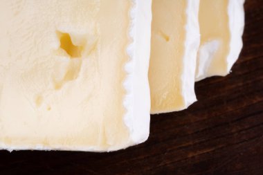 Ahşap rustik bir masada dilimlenmiş kokulu camembert peyniri