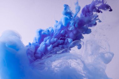 Renkli Mürekkep suda dönüyor. Beyaz arka plan üzerinde ipeksi mürekkep bulutu.