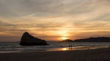 Çöl Beach'te batımında, gökte uçan martılar ile yürüme çift