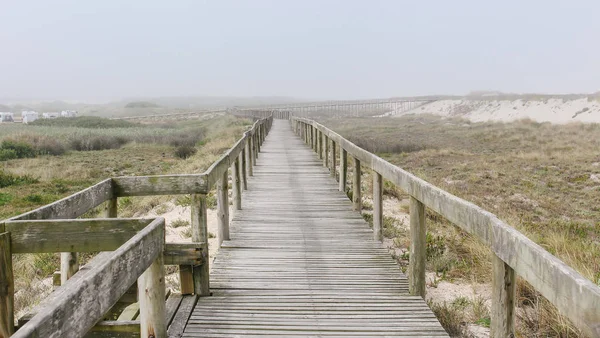 Sisli bir sabah Costa Nova Beach ahşap yaya köprüsü. Aveiro, Portekiz