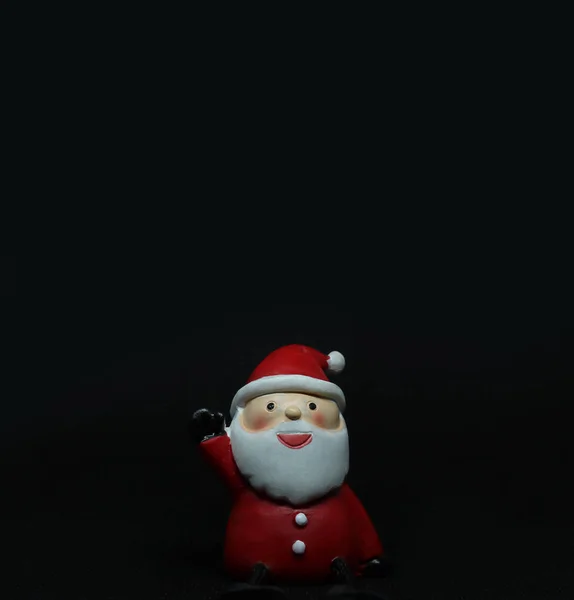 Cute santa claus doll in black background with copyspace above — Stock Photo, Image