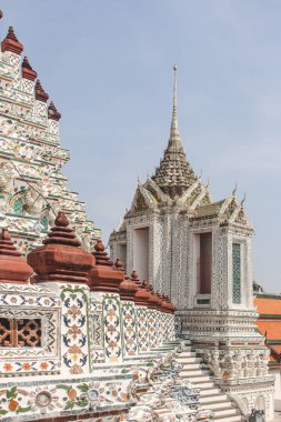 Chedi ve Wat Arun arka planda gökyüzü ile karışık seramik duvar detay. Bangkok, Tayland.