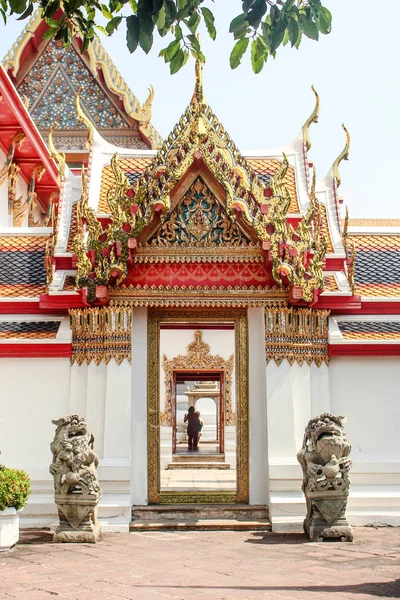 Bangkok, Tailândia - outubro de 2017: Estátuas de leão guardando a entrada do templo de Wat Pho, com casal à distância . — Fotografia de Stock