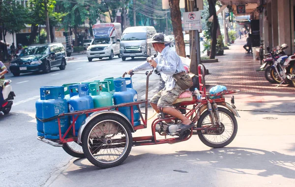 Bangkok, Tailândia - Outubro 2017: Macho tailandês transporte de gás engarrafado com motocicleta na rua movimentada de Bangkok . — Fotografia de Stock