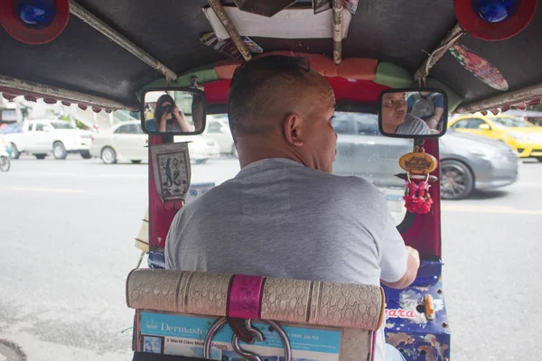 Bangkok, Tailandia - Octubre 2017: Vista desde el interior de un Tuk Tuk en las calles concurridas de Bangkok con el joven conductor tailandés . — Foto de Stock