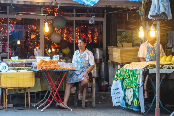 BANGKOK, THAILAND - Outubro 2017: vendedora de rua mulher tailandesa no mercado de Chatuchak vendendo seus doces e mercadorias artesanais . — Fotografia de Stock