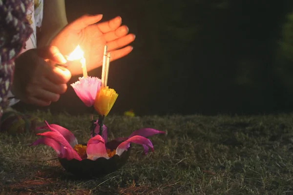 Frauen zünden Kerzen aus Krathong an, um den Krathong-Feiertag im Lumpini-Park zu feiern. — Stockfoto