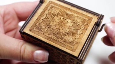 Kadının tutarak ve bir müzik kutusu oynayan eller. Makro karmaşık desenleri ve doku ile müzik kutusu.