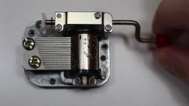 Müzik kutusu beyaz arka planda, parmak kolu dönüm. Makro müzik kutusu mekanizması ve vites olarak dönen çalış.