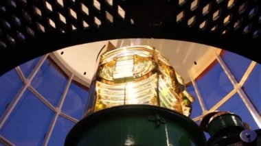 Güzel altın Fresnel lens deniz feneri içinde muhteşem ışıklar ve gölgeler ile lamba döndükçe yakın çekim.