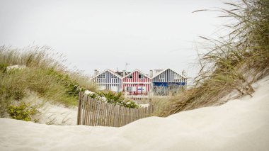 Pastoral ve şirin plaj evleri Beach kumulları gördün. Plaj evleri Costa Nova, Portekiz üzerinden renkli çizgili.
