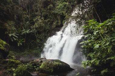 Mae Klang Luang gür yeşil yaprakları ile etkileyici şelale bakmak, uzun pozlama. Chiang Mai, Tayland.