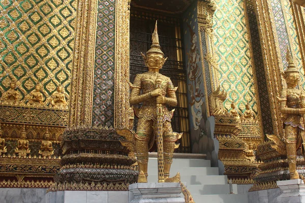 Phra Mondop Bangkok, Tayland Wat Phra Kaew tapınağında için büyük kapıyı koruyan altın dev heykeller.