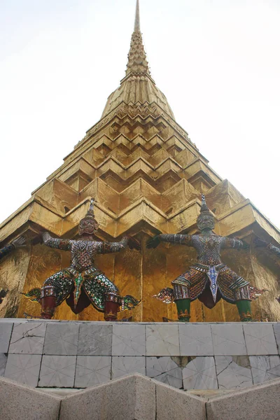 Estátuas de demônios segurando Golden Chedi prang no templo de Wat Phra Kaew. Bangkok, Tailândia . — Fotografia de Stock