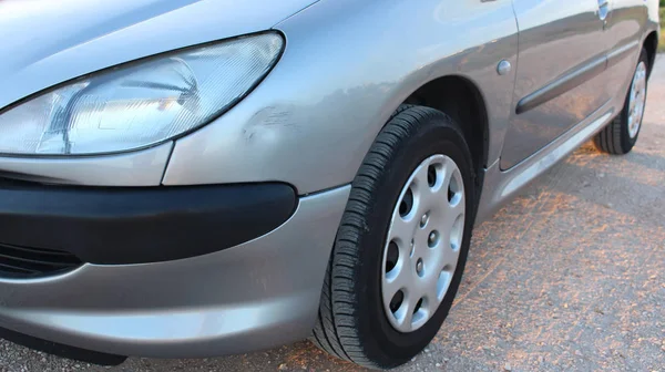 Küçük göçük ve yan çizikler gümüş gri araba. Kaza kaza, otopark ya da trafik hasar ile sepeti.