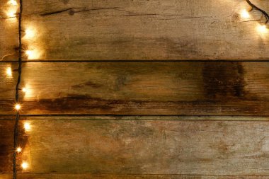 Düz rustik ve kırık ahşap masa knot, soldaki Noel ışıkları ile yatırın. Kopyalama alanı ile.