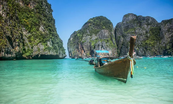 Maya Bay beach, Cennet Adası şeffaf su içerisinde yüzen uzun kuyruk tekne.