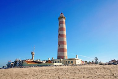 Aveiro, Portekiz-Mart 2019: açık mavi gökyüzüne karşı Praia da Barra feneri. Issız plaj.