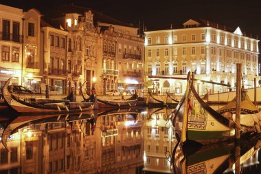 Güzel Aveiro Su Kanalları gece, iyi aydınlatılmış ve aydınlatılmış. Su yansımaları ile.