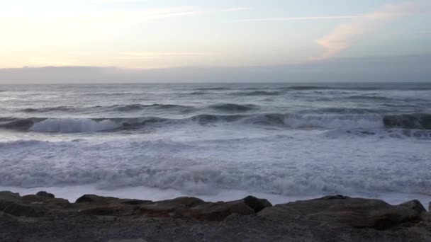 파도가 해안 근처 바위에 충돌, 늦은 여름 날. 포르투갈 바그기라에서. 복사 공간. — 비디오
