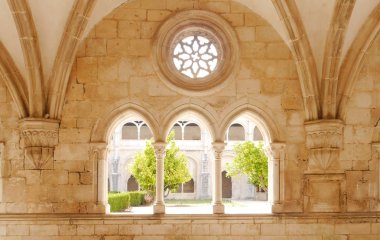 Alcobaca, Portekiz - Ağustos 2018: Alcobaca Manastırı'nın kemer ve gül pencerelerinden manastır bahçesinin manzarası.