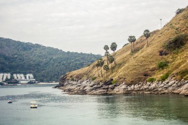 Phuket Yanui Beach dağlar ve palmiye ağaçları ile güzel manzara. Zevk el sanatları deniz suyu demirlemiş.