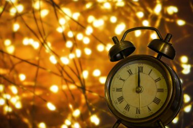 Arka planda Bokeh sarı ışıkları olan, kopyalama alanı olan klasik çalar saat. Gece yarısı ve yeni yıl arifesi kavramı.