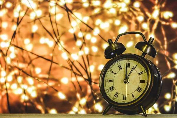 Arkaplan olarak bokeh sarı ışıklar, kopyalama alanı olan klasik saat.