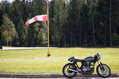 Havaalanında motosiklet. Rüzgarın arkada. Motorcu bir uçağa.